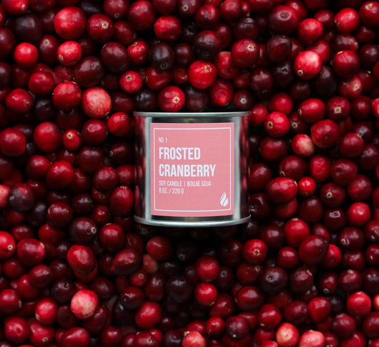 Product photograph of Frosted Cranberry candle on top of a bed of cranberries.