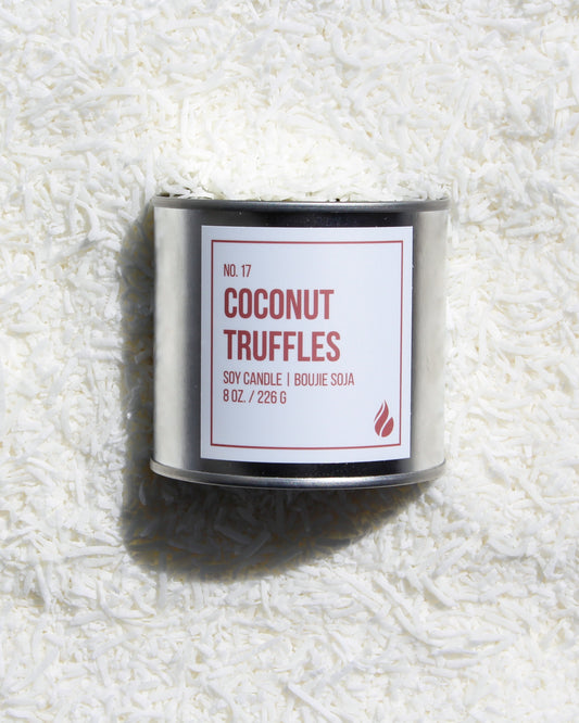 Photo of Coconut Truffles Candle laying on coconut flakes.